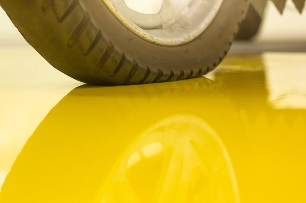 Tire resting on a glossy solid yellow epoxy floor